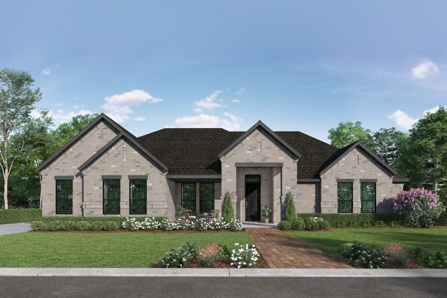 Single-story residential home with a landscaped front yard and a clear sky.