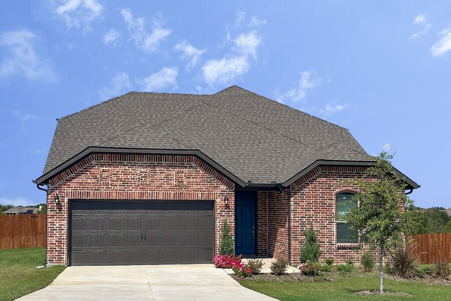 Suburban brick house with a two-car garage and a blue front door.