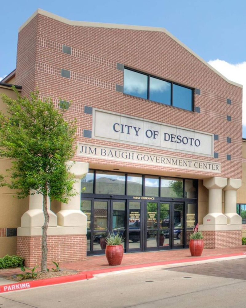 A brick government building with a sign reading "city of desoto - jim baugh government center.