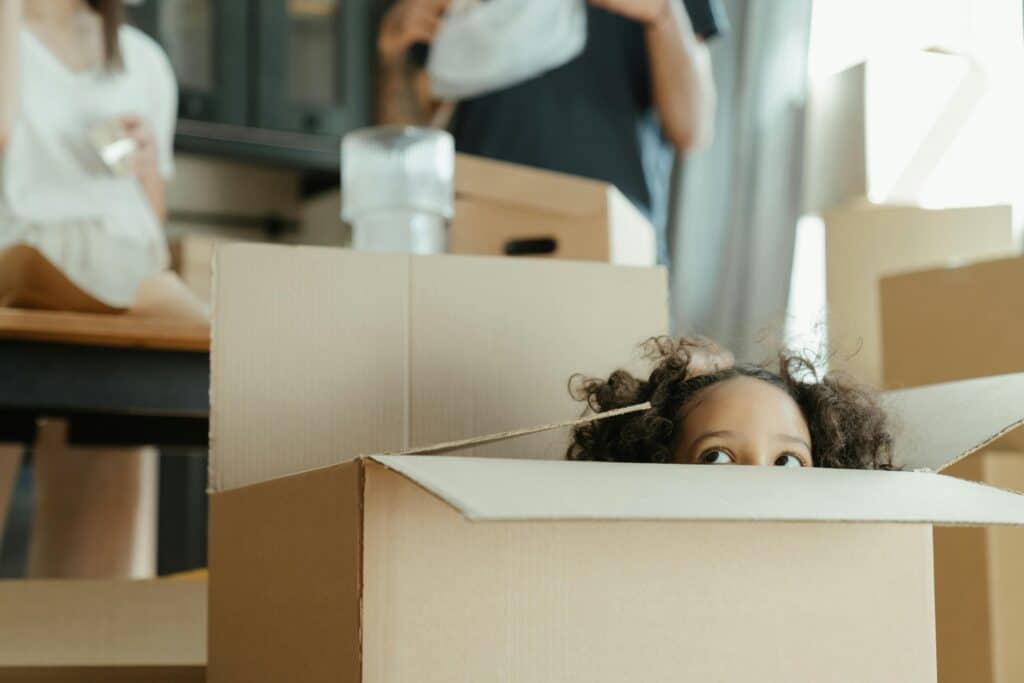 little girl peeping out of moving box