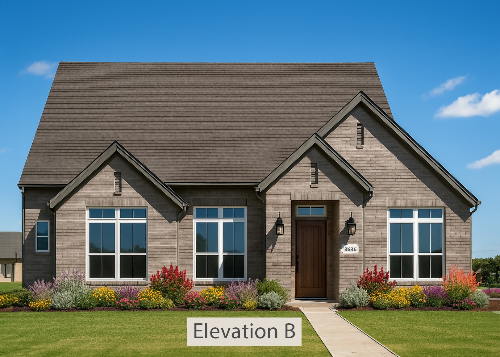 A single-story, light brown brick house with a dark brown shingle roof under a clear blue sky. The home features white-framed windows, a dark wood front door, black exterior lanterns, and a small flowerbed with colorful blooms.
